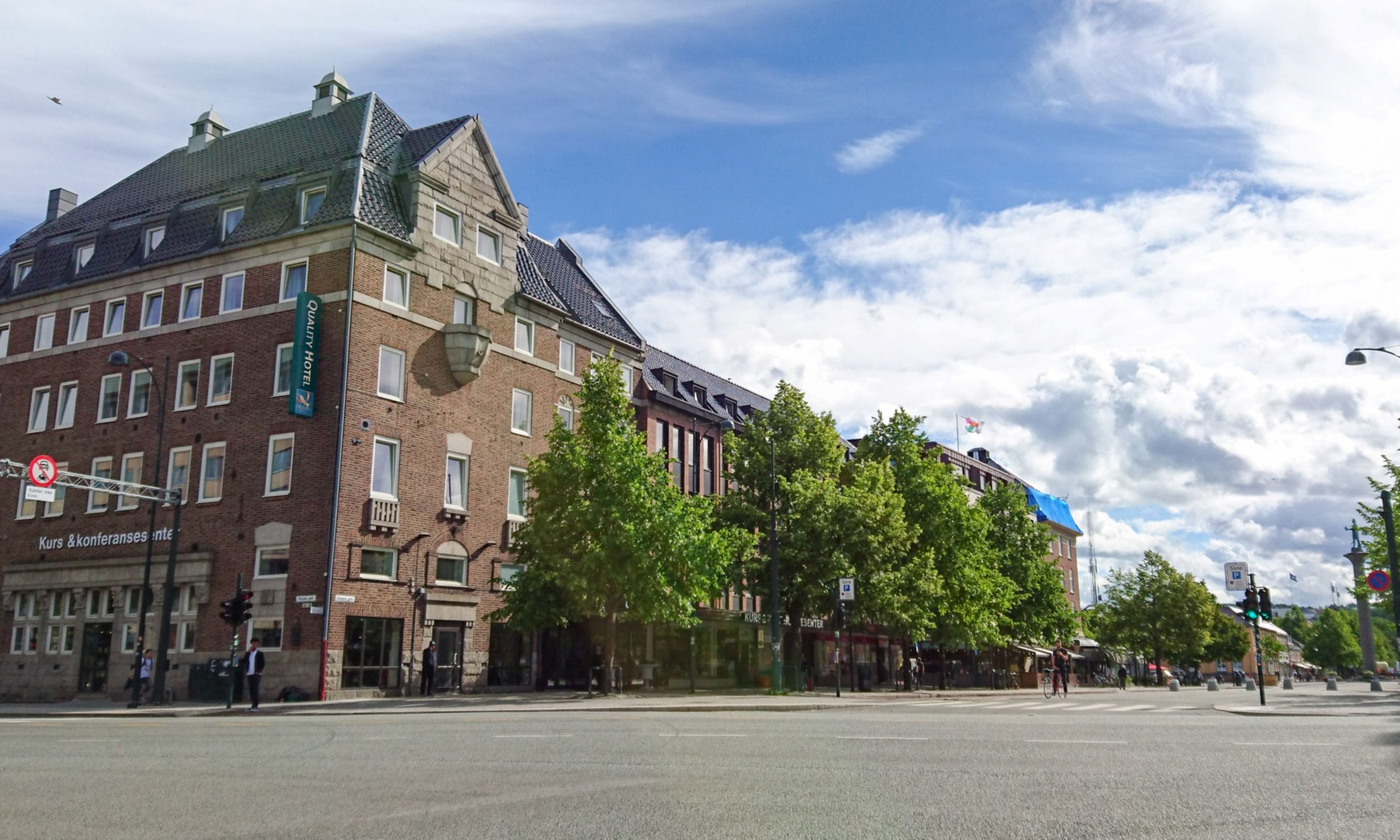 Hotel facade sourunded by green trees in summer.