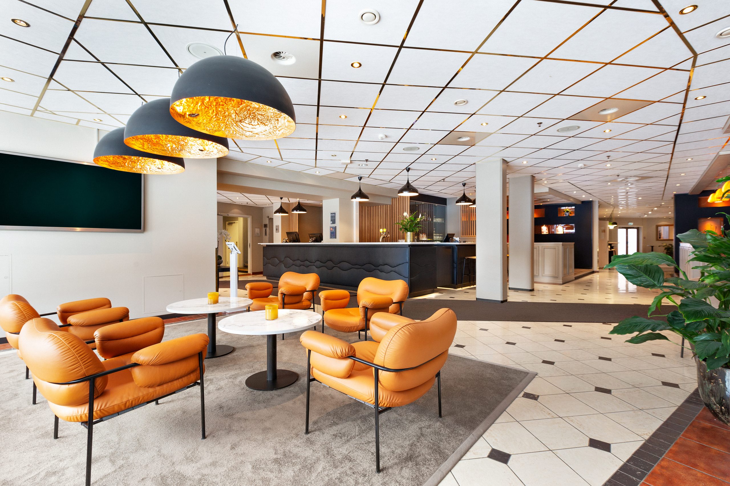 A hotel lobby with orange sofas.